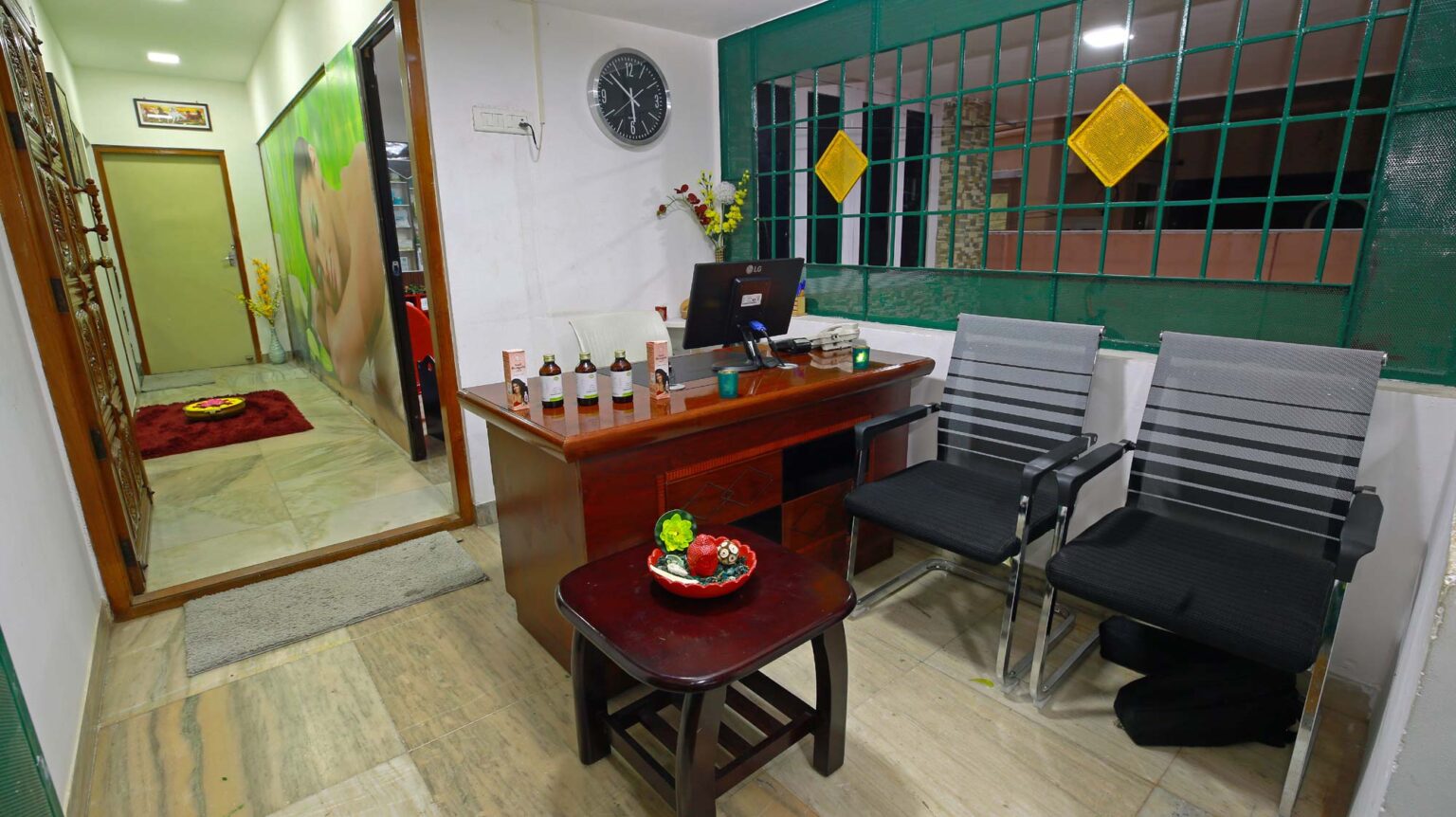Room with comfortable chairs ,table, computer, display oils, carpet and windows for ventilation. Come, have a look at the products that we use for Spa massage at the welcome room of the City's best Ayurvedic and Spa Massage parlour, The Riverday Spa