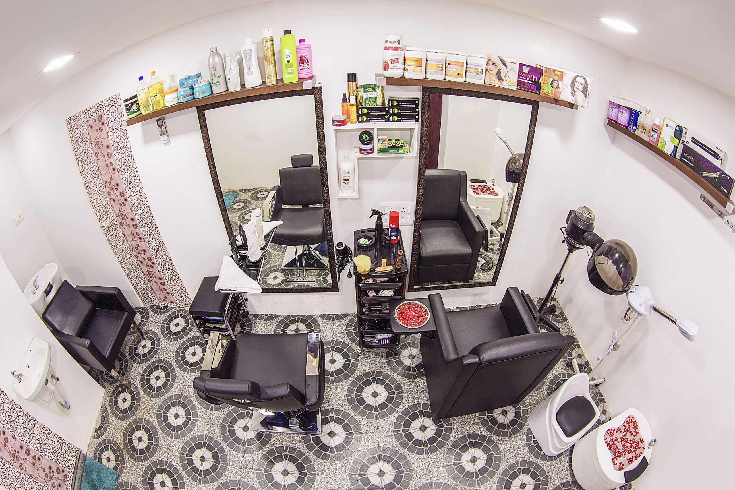Interior of a beauty parlour room, featuring couches for pedicure, manicure and makeup procedures along with accessories and products for the skincare procedures.
